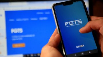 salvador, bahia, brazil - december 8, 2020: person with cell phone trying to access the FGTS page on the Caixa Economica Federal website in the city of Salvador.